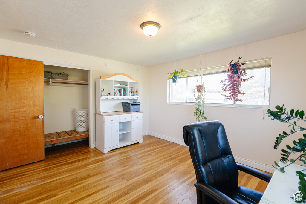 Office area featuring light wood-style flooring and baseboards