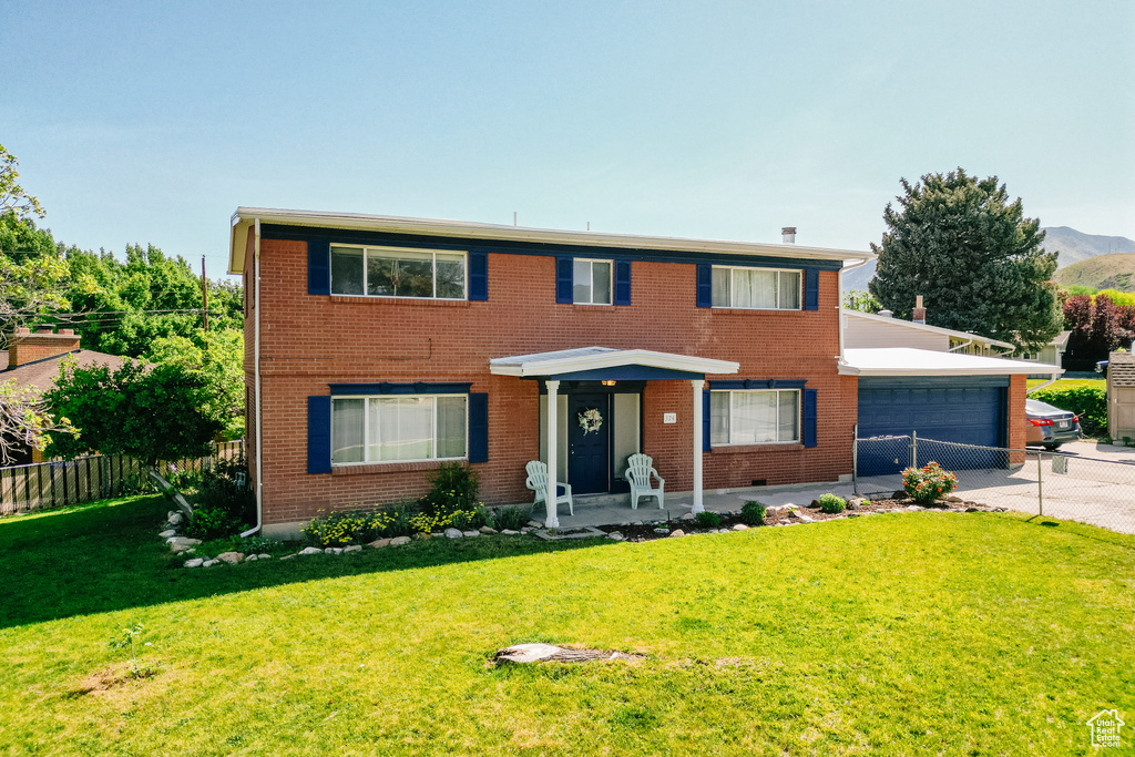 View of front of house with driveway, brick siding, and a garage