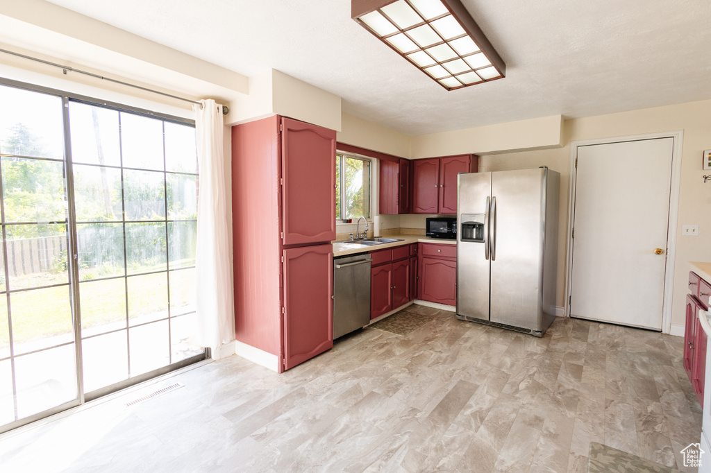 Kitchen featuring stainless steel appliances, a sink, and light countertops