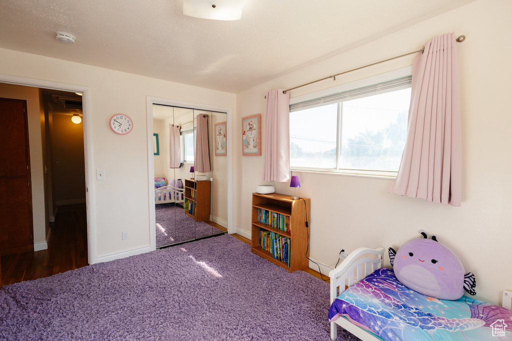 Carpeted bedroom featuring a closet and baseboards