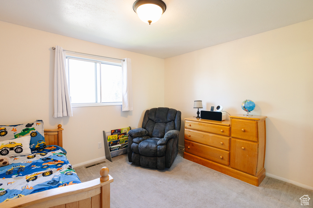 Bedroom with light colored carpet and baseboards