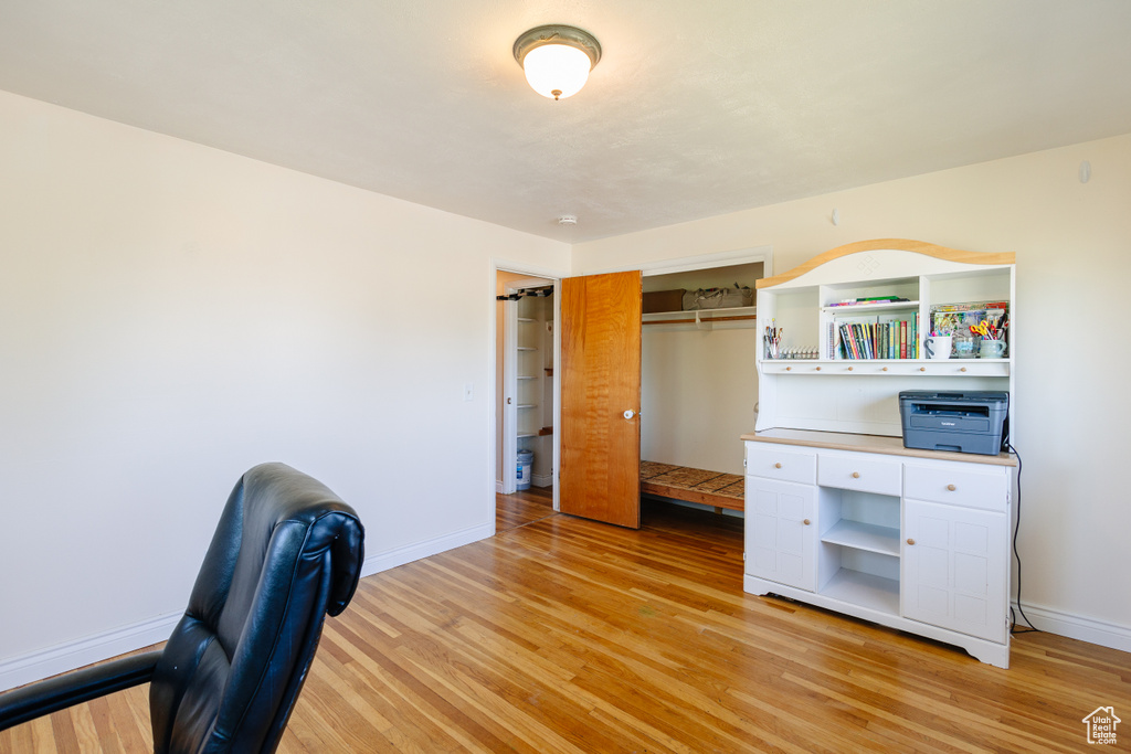 Unfurnished office featuring baseboards and light wood-style flooring
