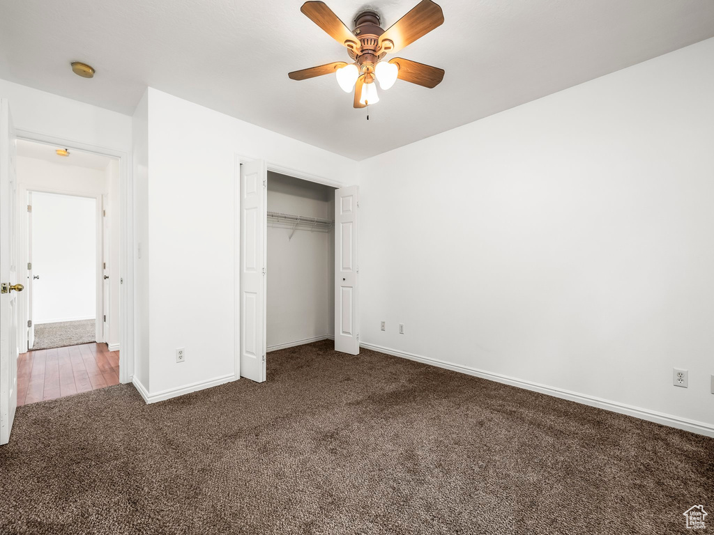 Unfurnished bedroom featuring carpet floors, baseboards, a closet, and ceiling fan