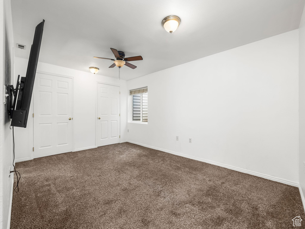Unfurnished bedroom featuring dark carpet and baseboards