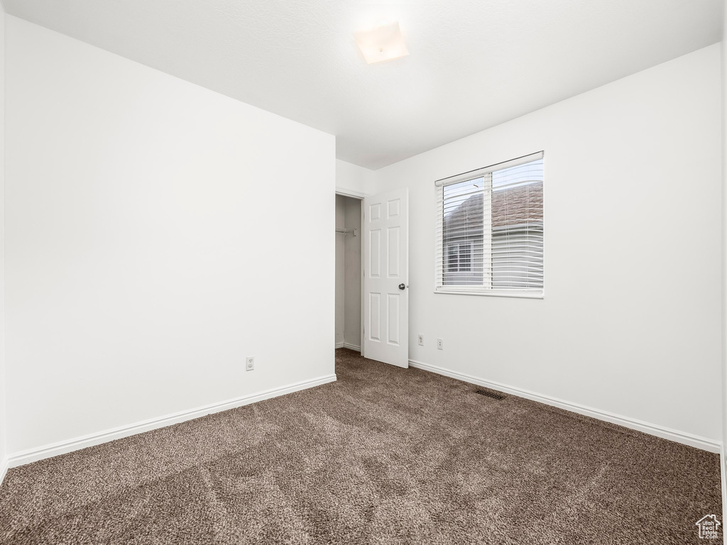 Carpeted empty room with baseboards