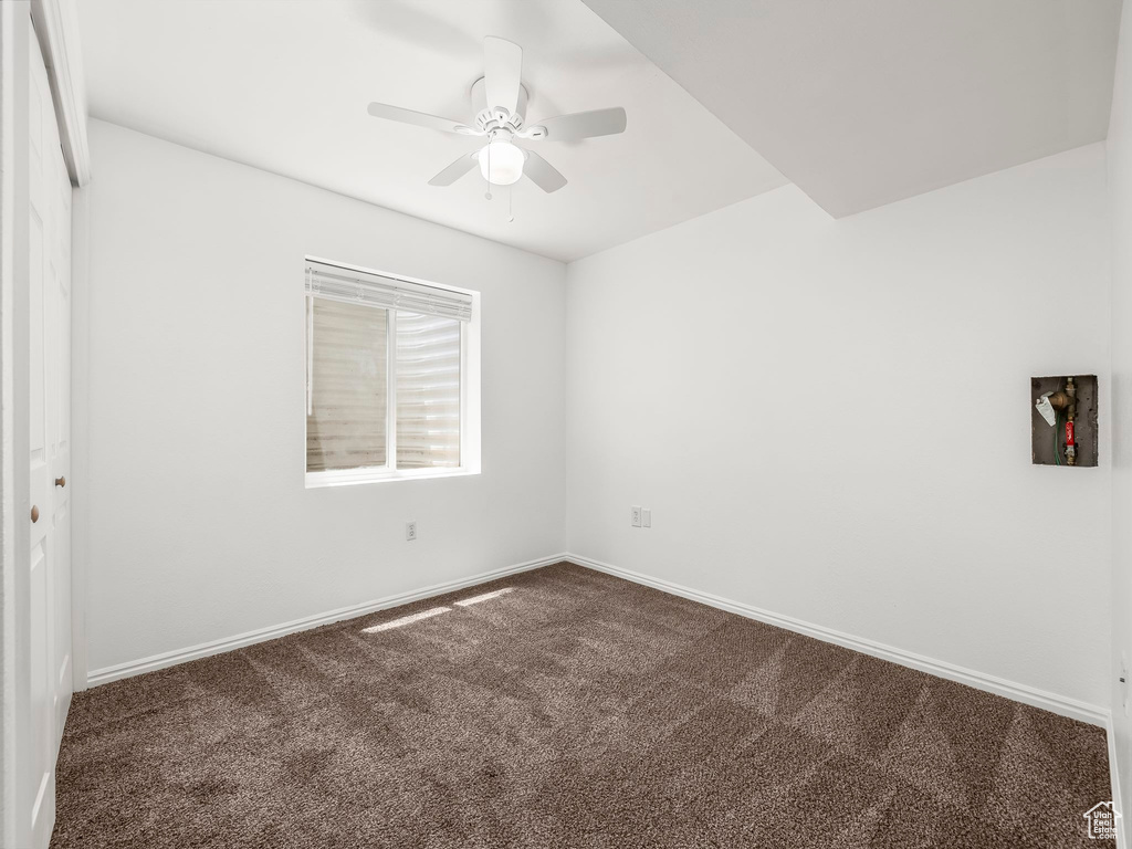 Empty room with carpet floors, ceiling fan, and baseboards