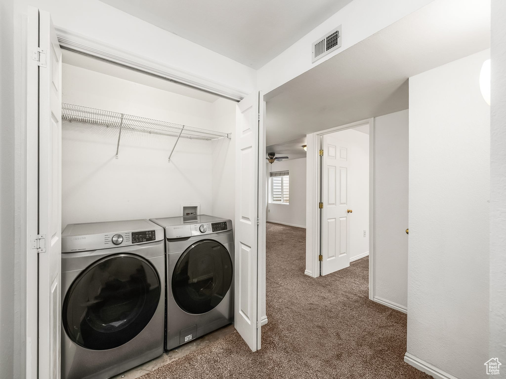 Laundry room with separate washer and dryer, carpet, and baseboards
