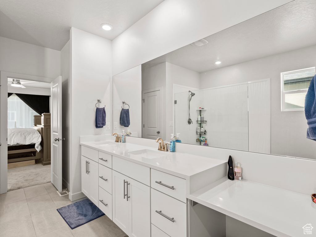 Bathroom featuring ensuite bath, double vanity, ceiling fan, recessed lighting, and tile patterned flooring