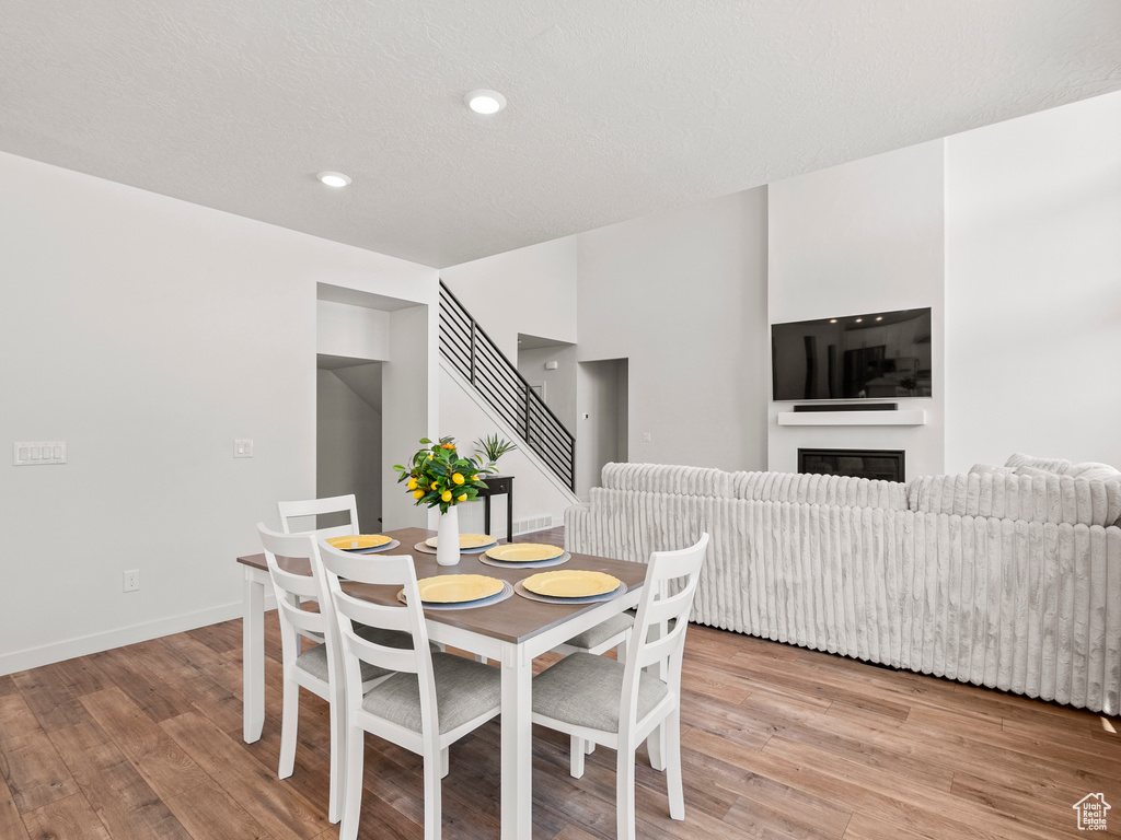 Dining space with light wood-type flooring, recessed lighting, a glass covered fireplace, and baseboards