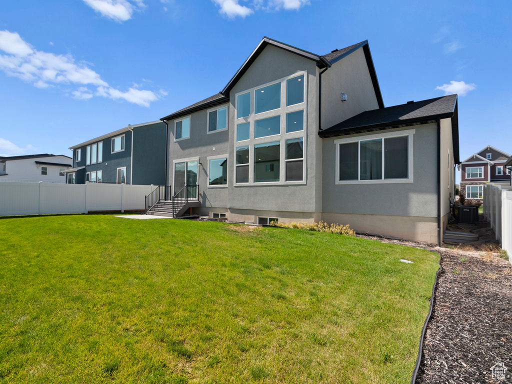 Rear view of property featuring stucco siding and central air condition unit