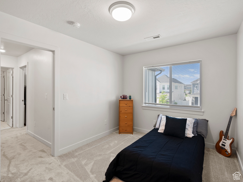Bedroom with light carpet and baseboards