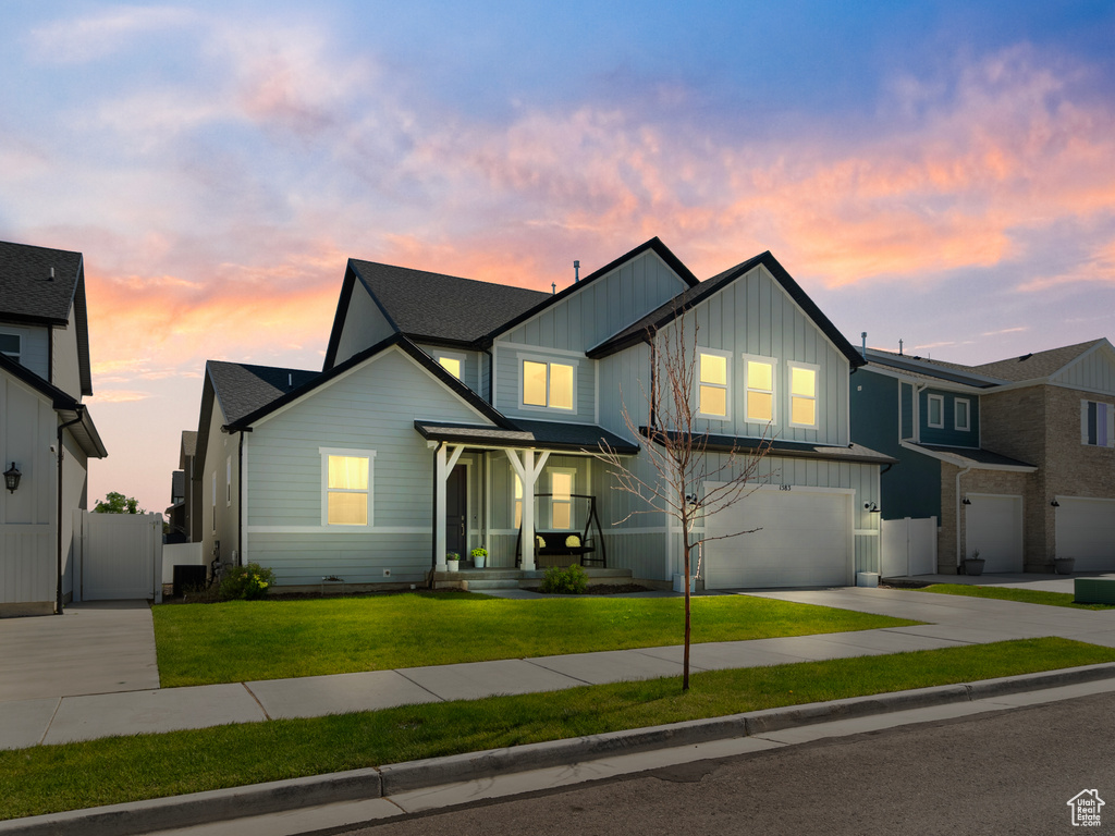 View of front of property with board and batten siding, concrete driveway, and a garage