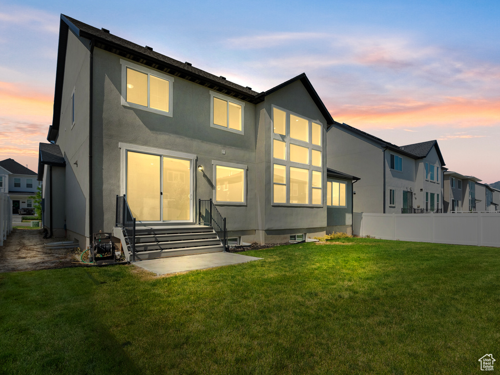 Back of house at dusk with entry steps and stucco siding