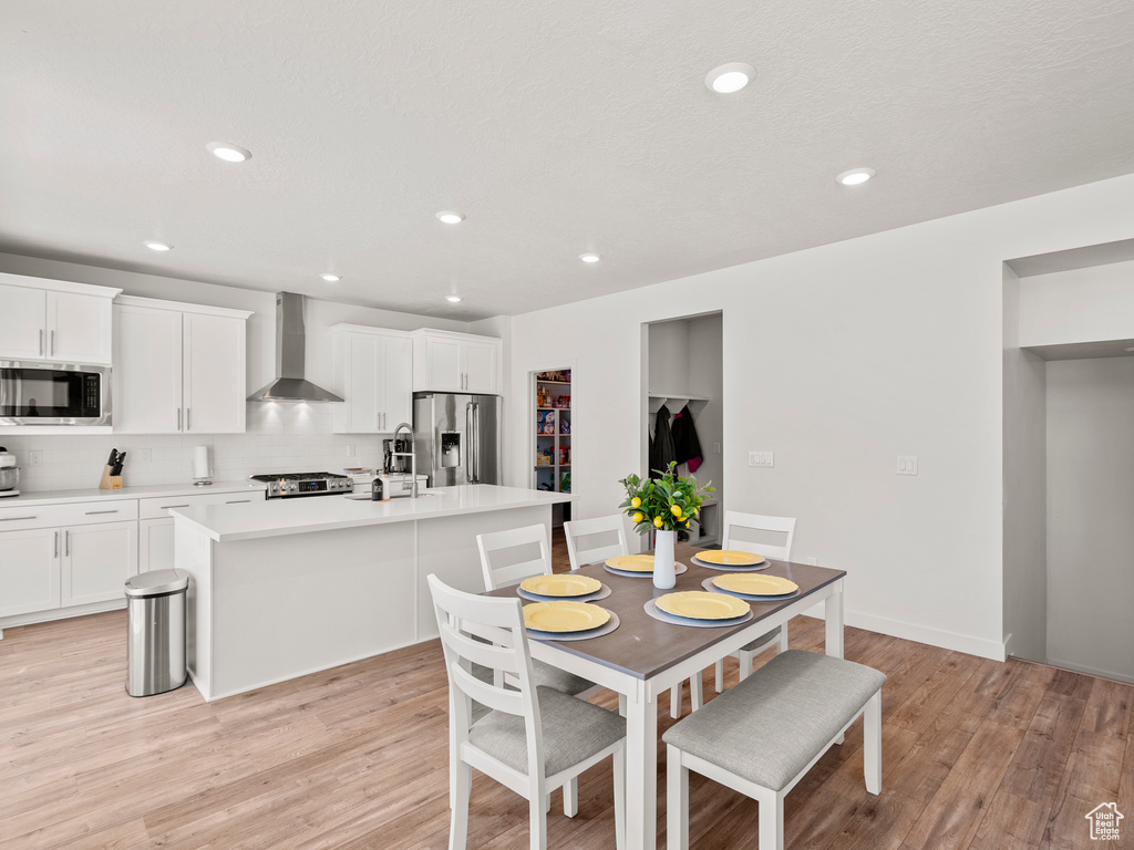 Dining area featuring light wood finished floors and recessed lighting