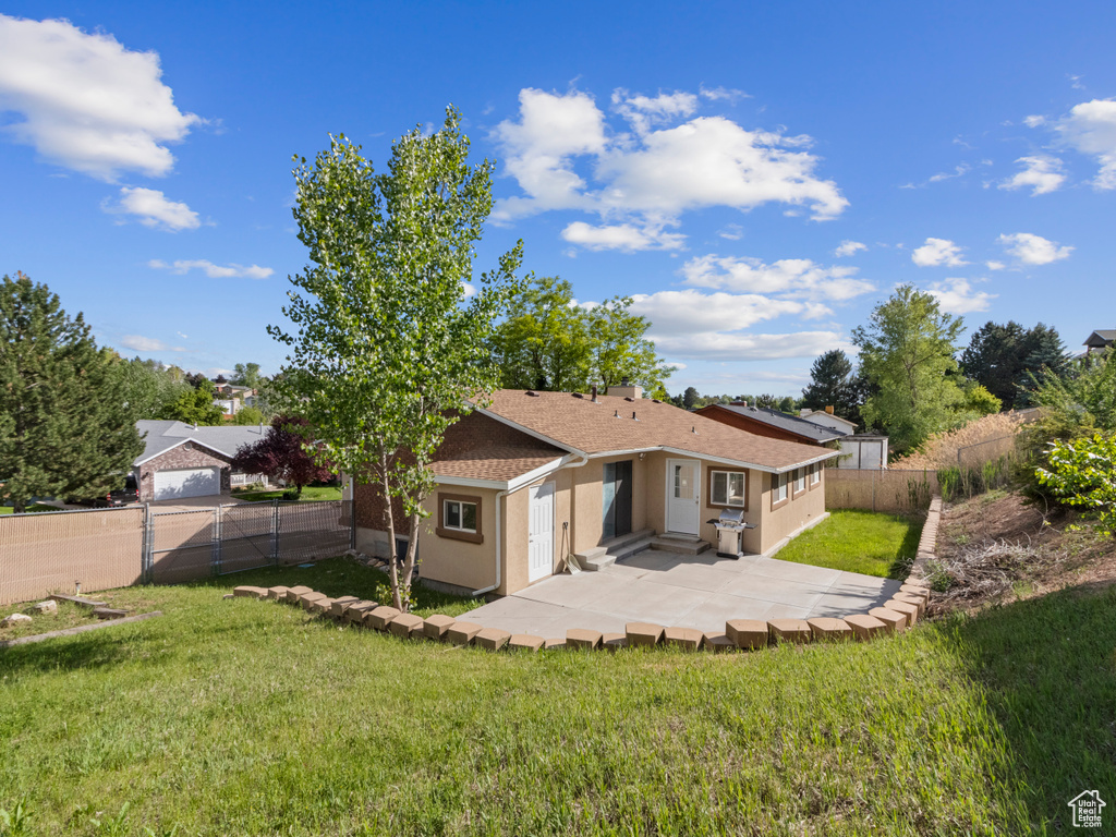 Back of property with a patio, stucco siding, and roof with shingles