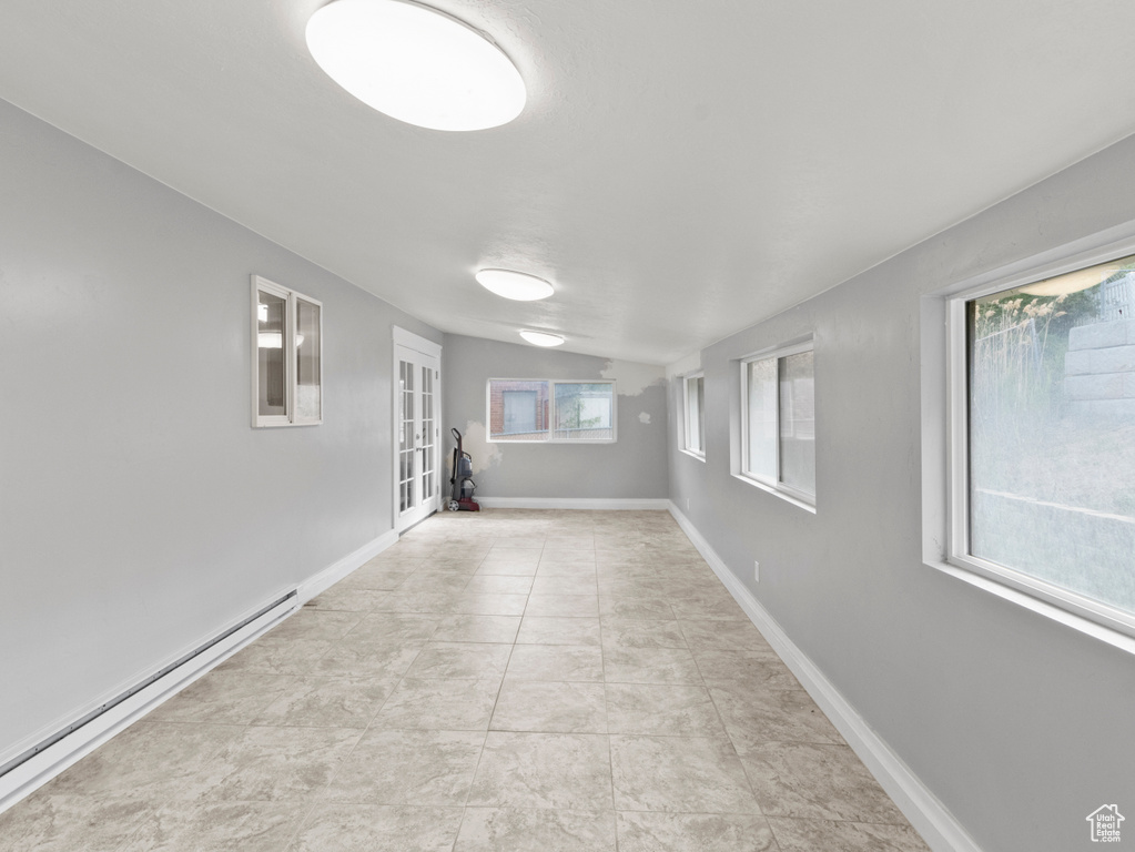 Spare room featuring a baseboard heating unit, french doors, and baseboards