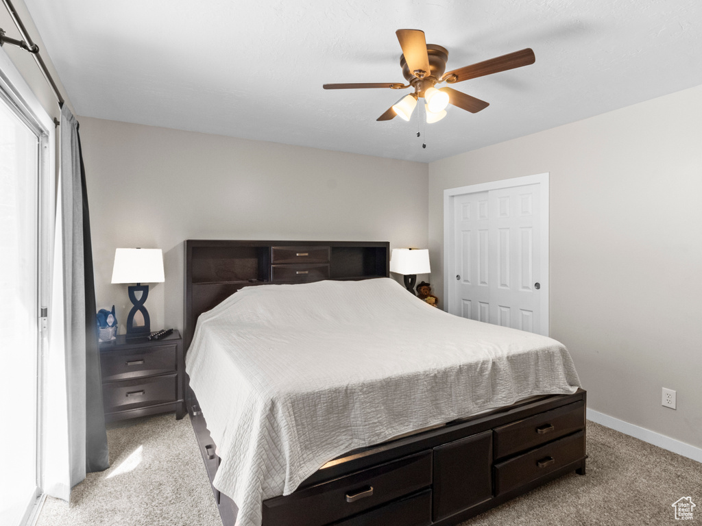 Bedroom with carpet, baseboards, ceiling fan, and a closet