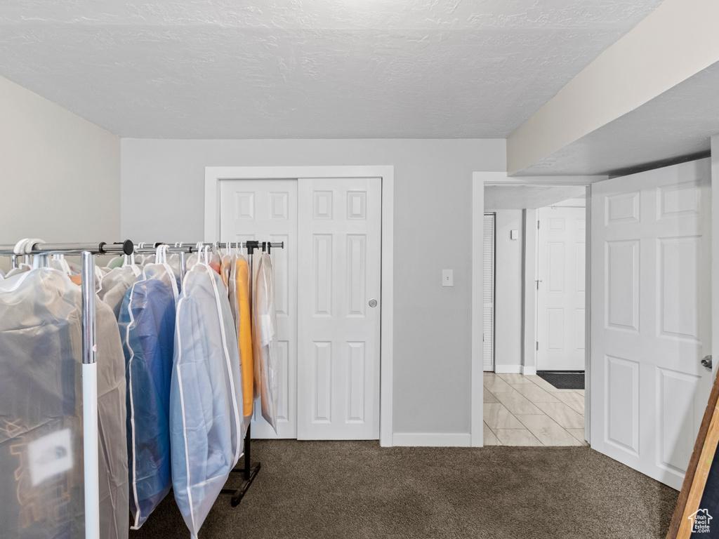 Carpeted bedroom with baseboards and a closet