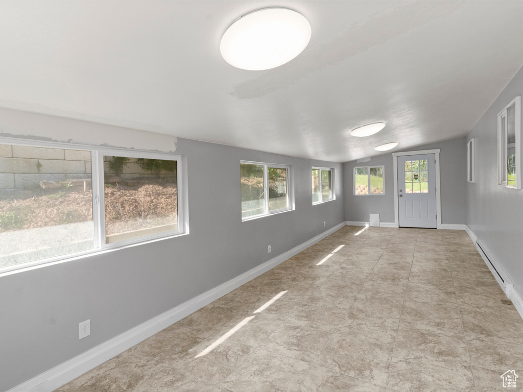 Unfurnished sunroom featuring lofted ceiling