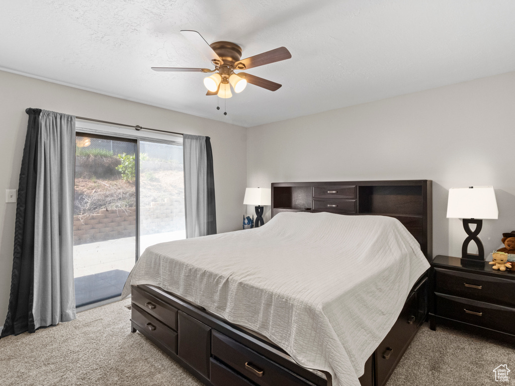 Bedroom featuring light colored carpet, access to exterior, and a ceiling fan