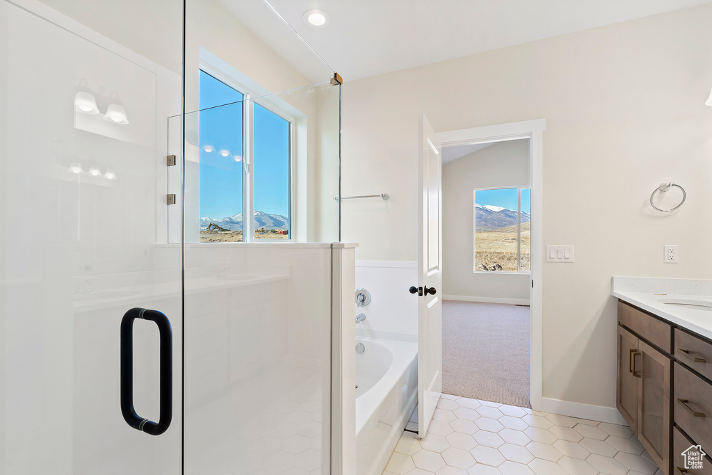 Full bathroom with vanity, a bath, a shower stall, tile patterned floors, and baseboards