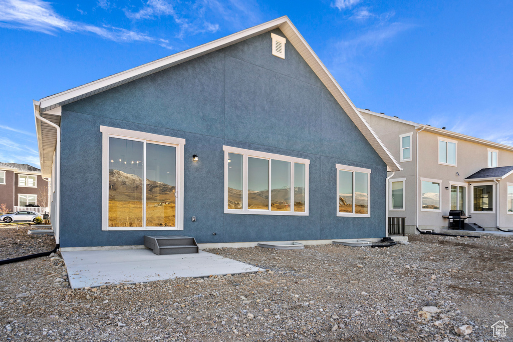Back of house with a patio and stucco siding