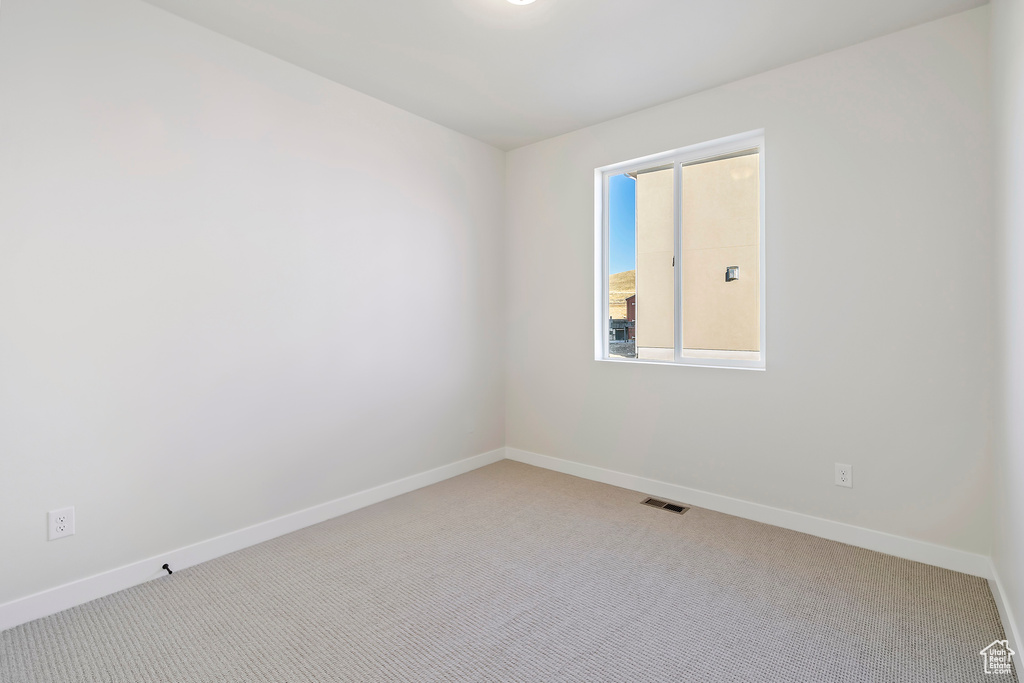 Carpeted spare room with baseboards