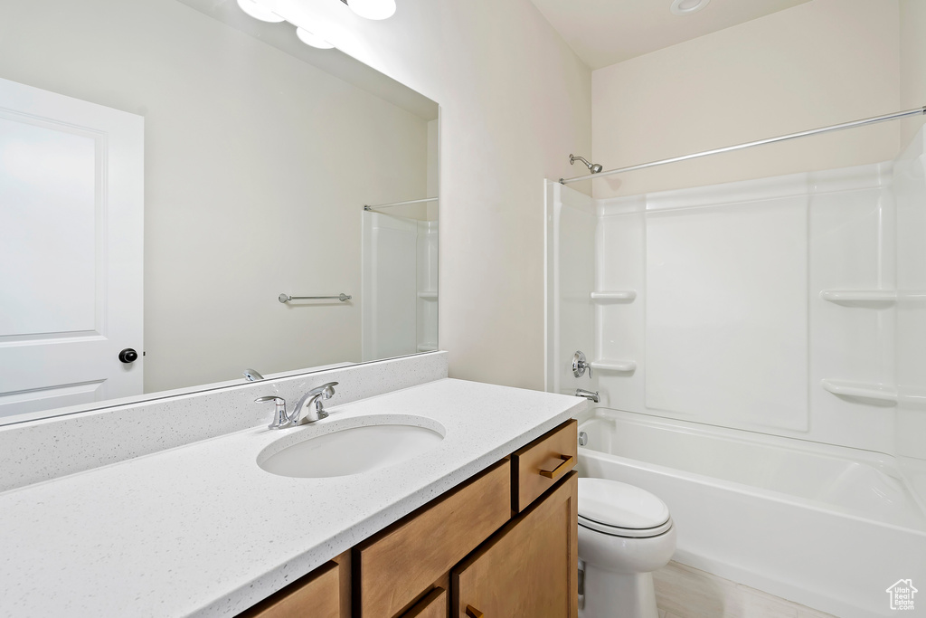 Bathroom featuring vanity, shower / bathtub combination, and toilet