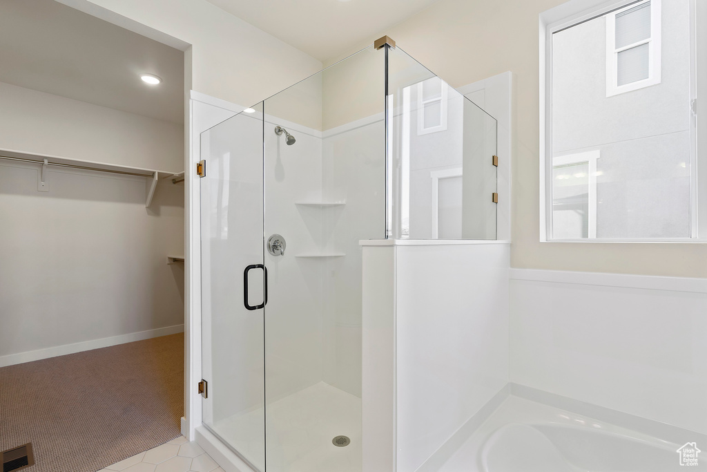 Bathroom featuring a shower stall, a spacious closet, a bath, and recessed lighting