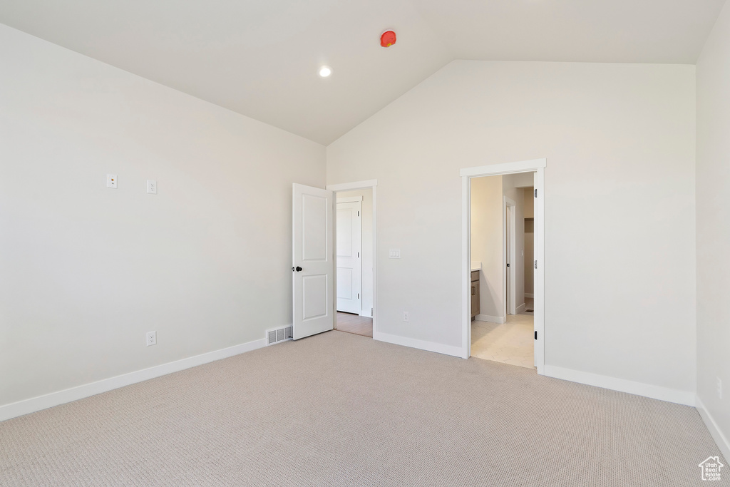 Unfurnished bedroom with high vaulted ceiling, light colored carpet, baseboards, and recessed lighting
