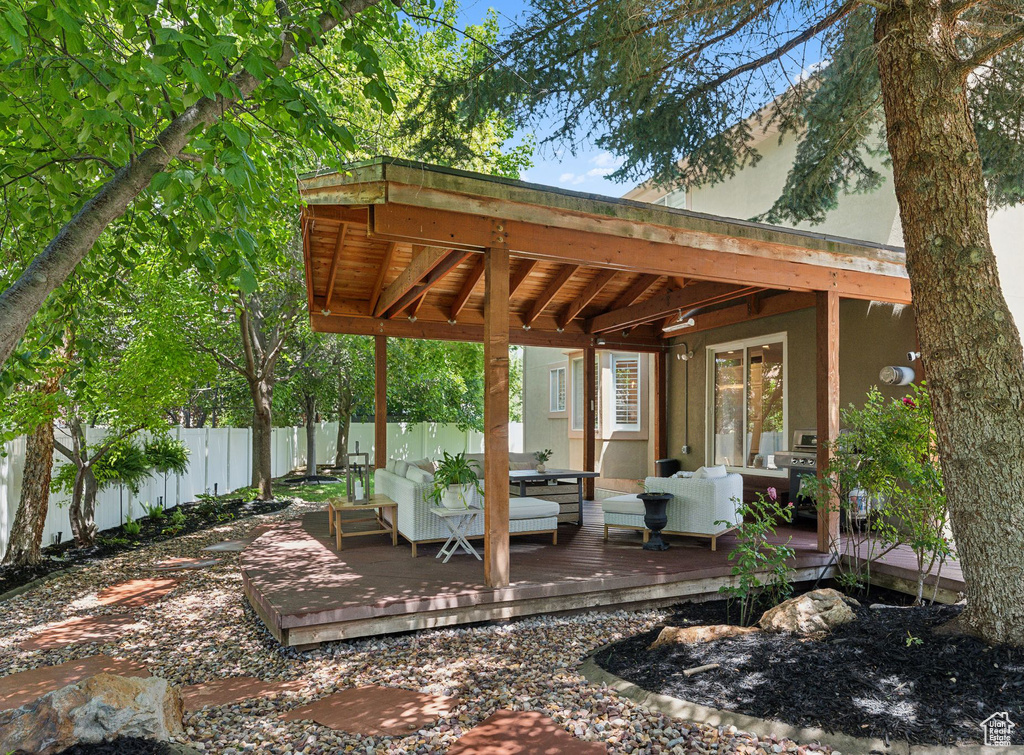 Fenced backyard featuring a wooden deck and an outdoor hangout area