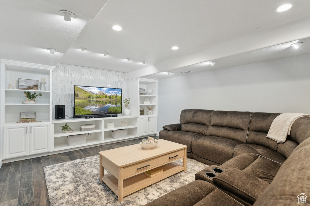 Living area with dark wood-style floors, recessed lighting, and built in features