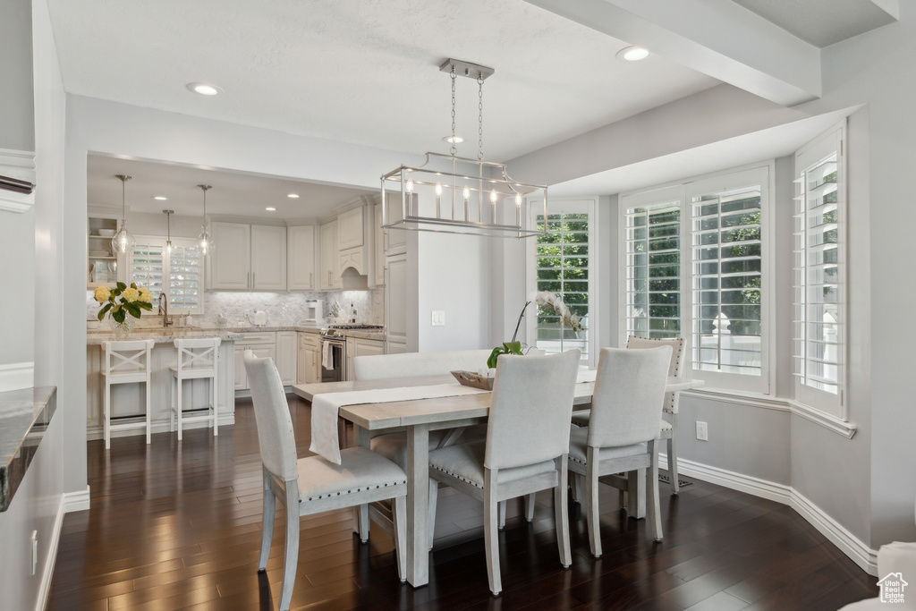 Dining space with dark wood-style floors, a chandelier, recessed lighting, and baseboards