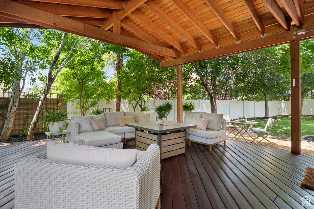 Wooden terrace with outdoor lounge area, a fenced backyard, and outdoor dining space