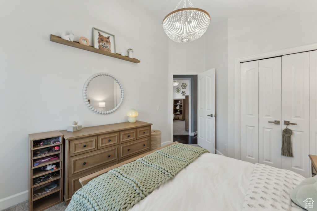 Bedroom with a closet, a chandelier, and baseboards