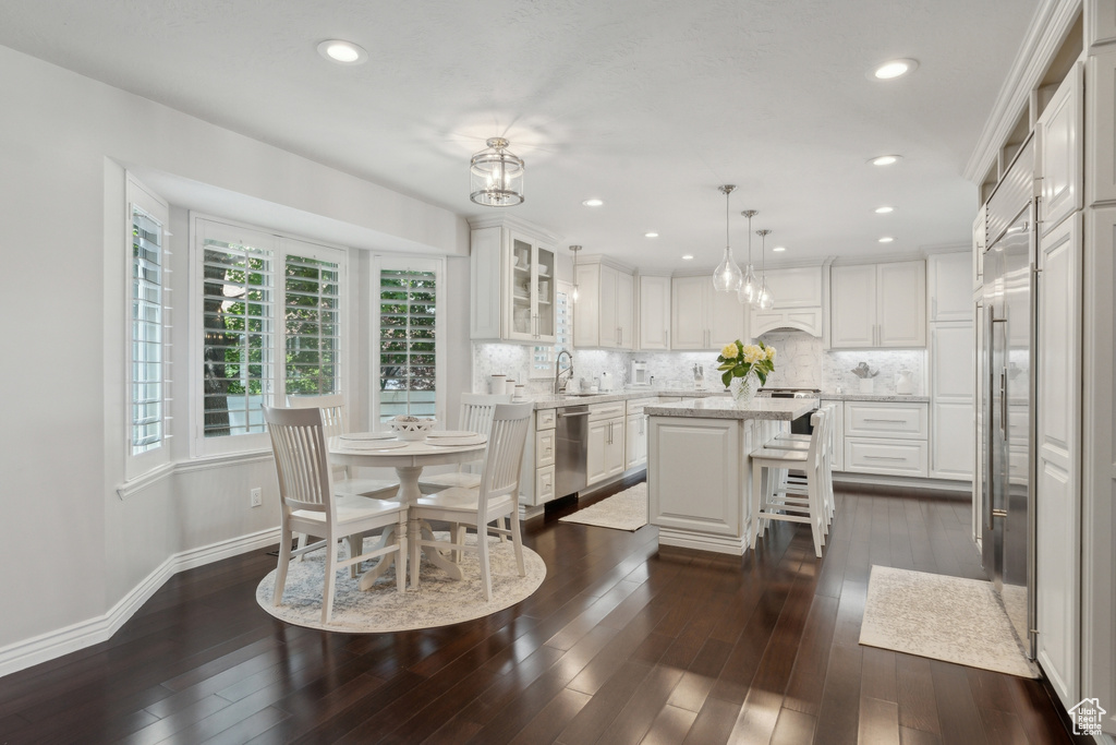Dining area featuring dark wood-type flooring, baseboards, and recessed lighting