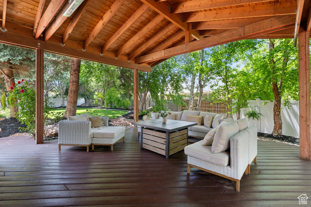 Wooden deck with an outdoor hangout area and a fenced backyard