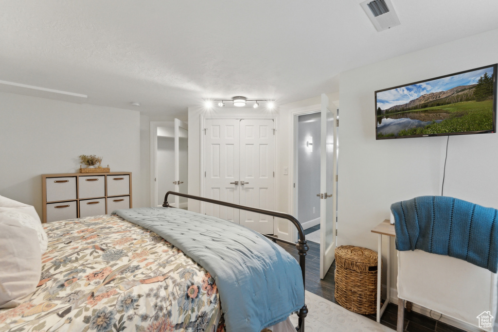 Bedroom with wood finished floors and a closet
