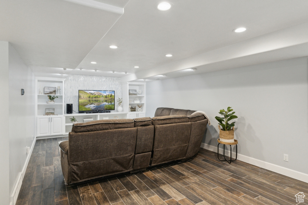 Living area with baseboards, recessed lighting, dark wood-type flooring, and built in shelves