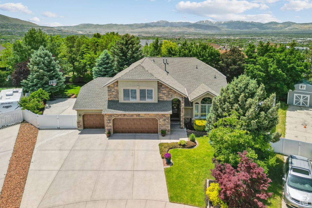French provincial home featuring stone siding, a mountain view, driveway, and a gate