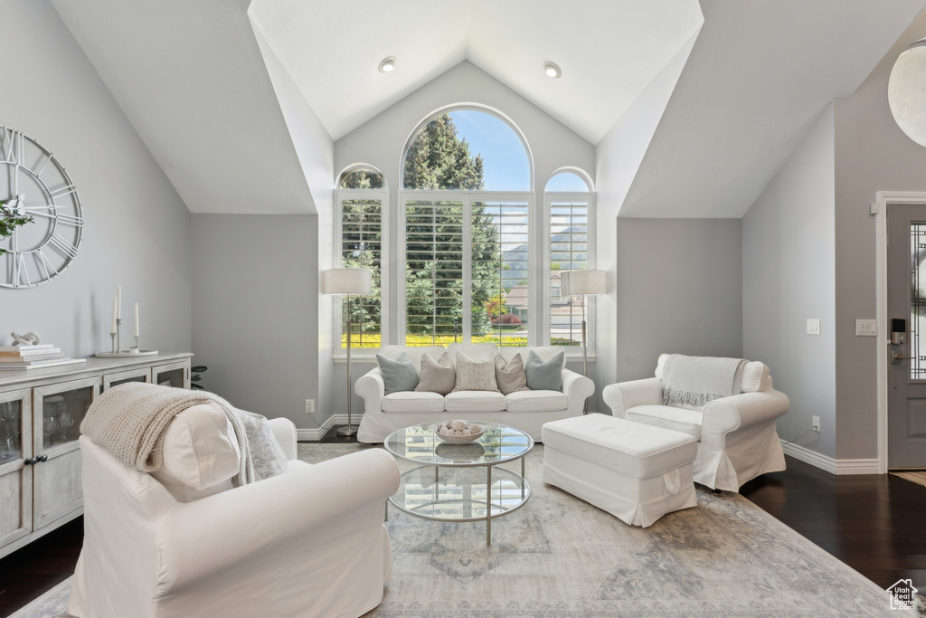 Living area featuring wood finished floors, vaulted ceiling, and baseboards