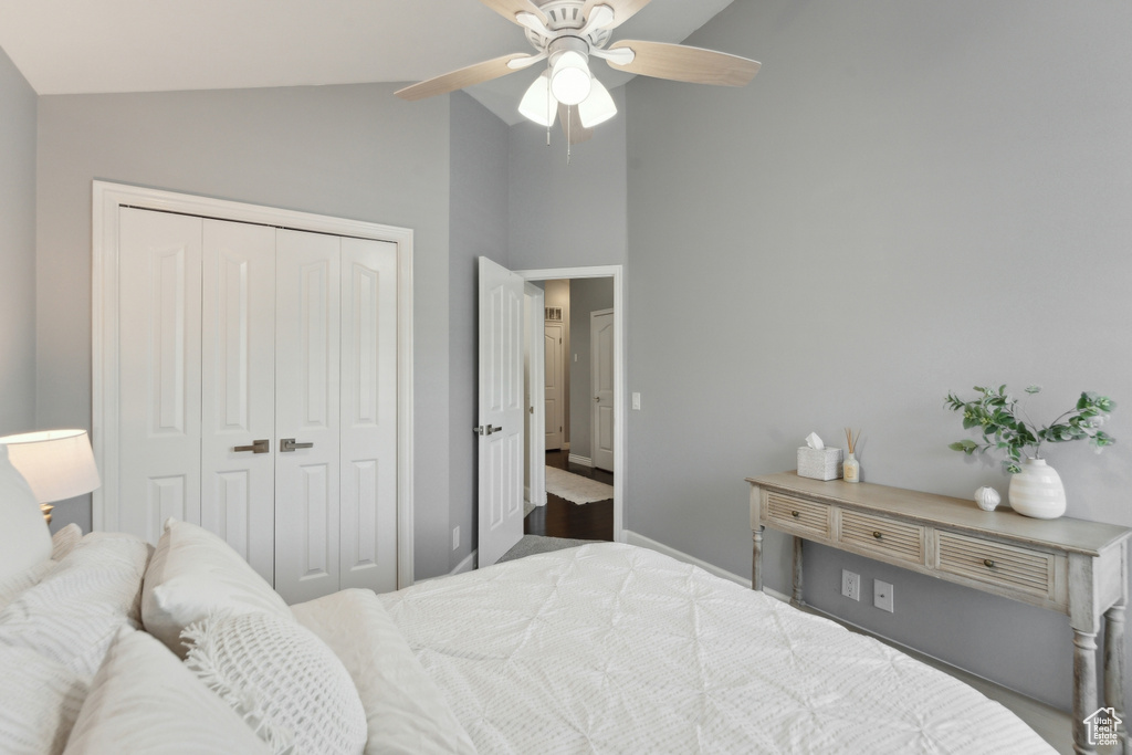 Bedroom featuring a closet, a ceiling fan, baseboards, and high vaulted ceiling