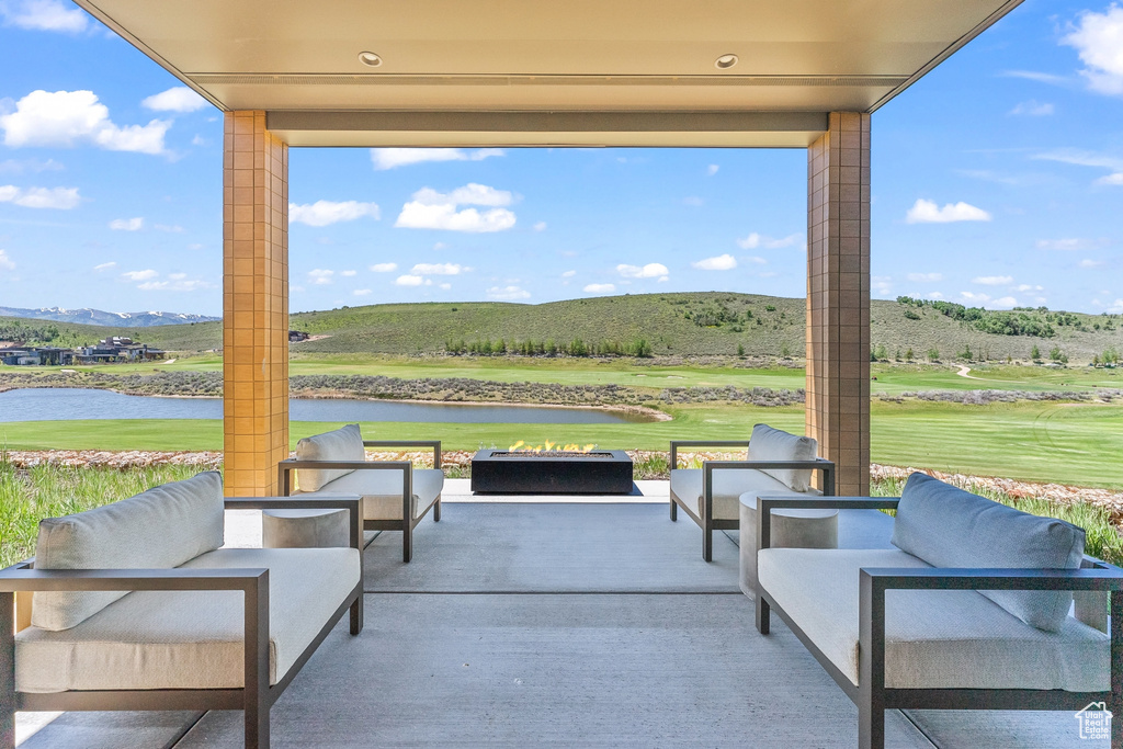 View of patio featuring an outdoor living space with a fire pit, a water and mountain view, and golf course view