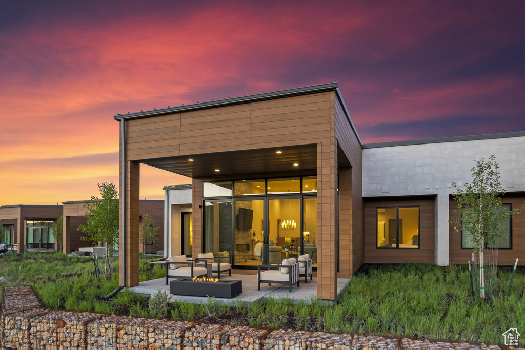 Back of house with an outdoor living space and a patio area