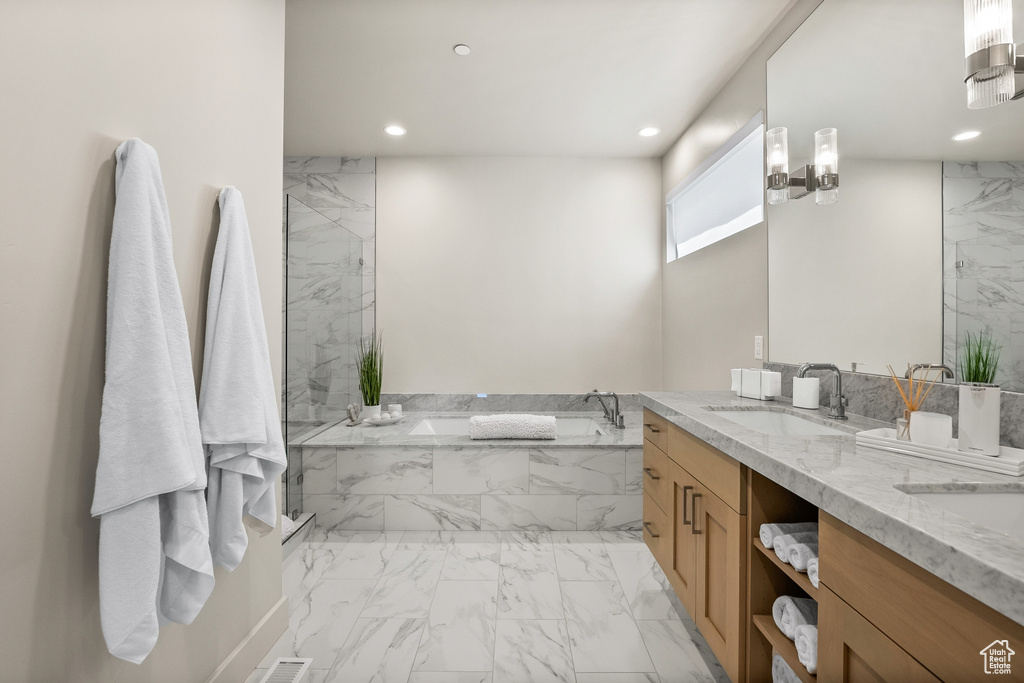 Bathroom featuring marble finish floors, a garden tub, recessed lighting, double vanity, and a marble finish shower