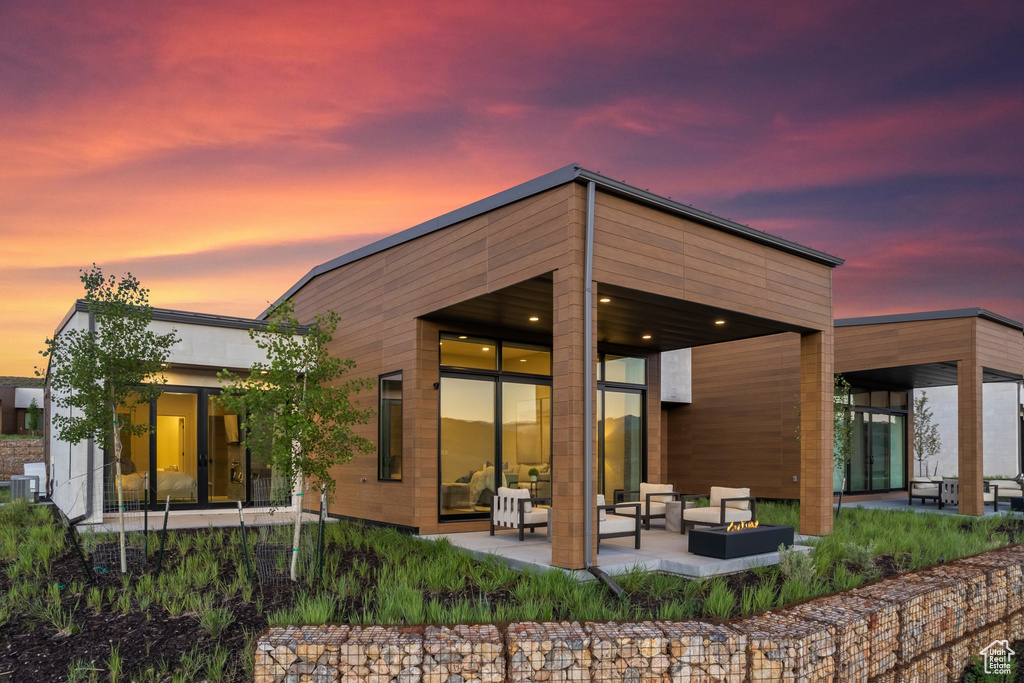 Back of house featuring an outdoor living space with a fire pit and a patio area