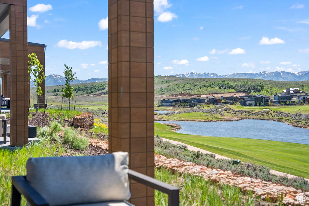 View of patio featuring golf course view and a water and mountain view