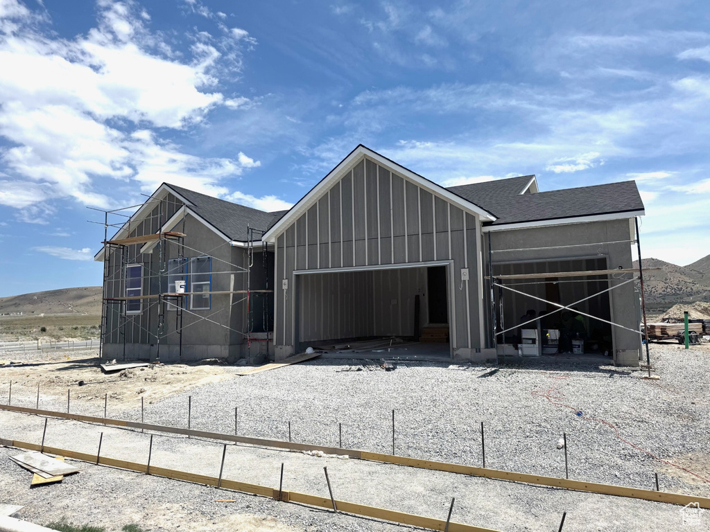 View of front of house featuring a garage, board and batten siding, and a shingled roof