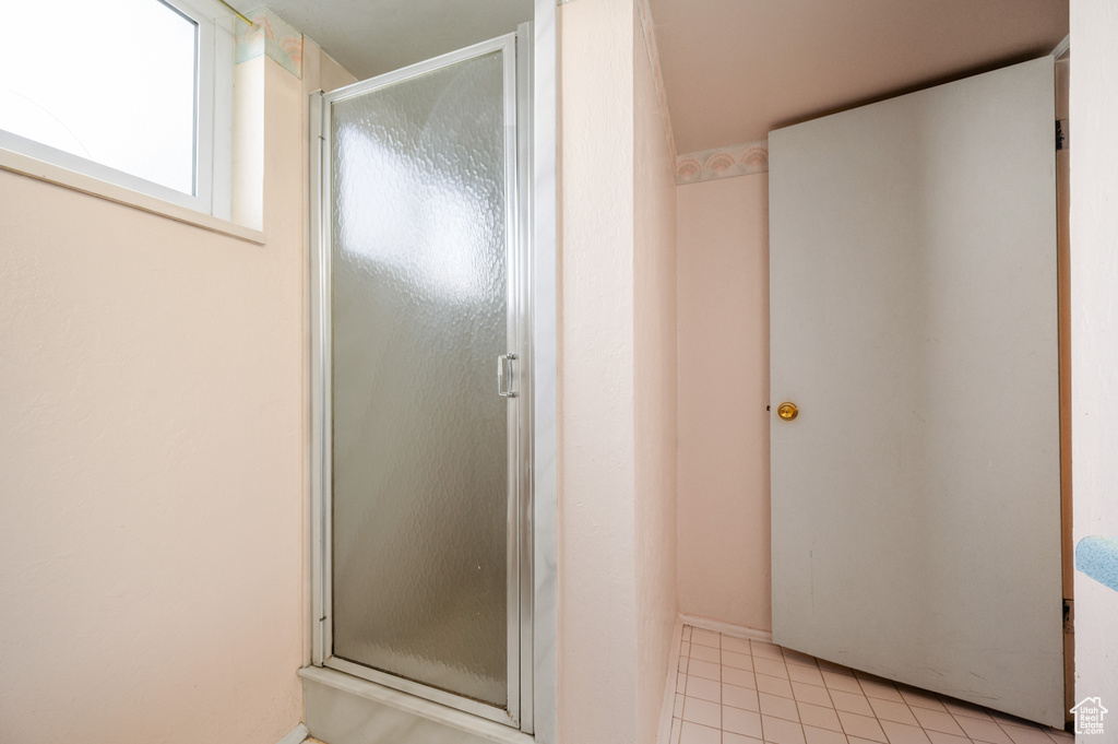 Bathroom with a stall shower and tile patterned floors
