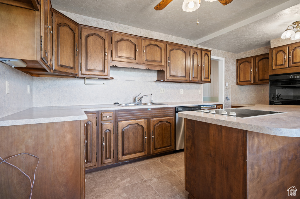 Kitchen with black appliances, a sink, a textured ceiling, light countertops, and ceiling fan